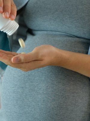 Pregnant woman taking pills.