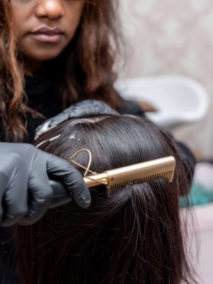 Image of a professional making a new hairstyle to a woman with black hair.