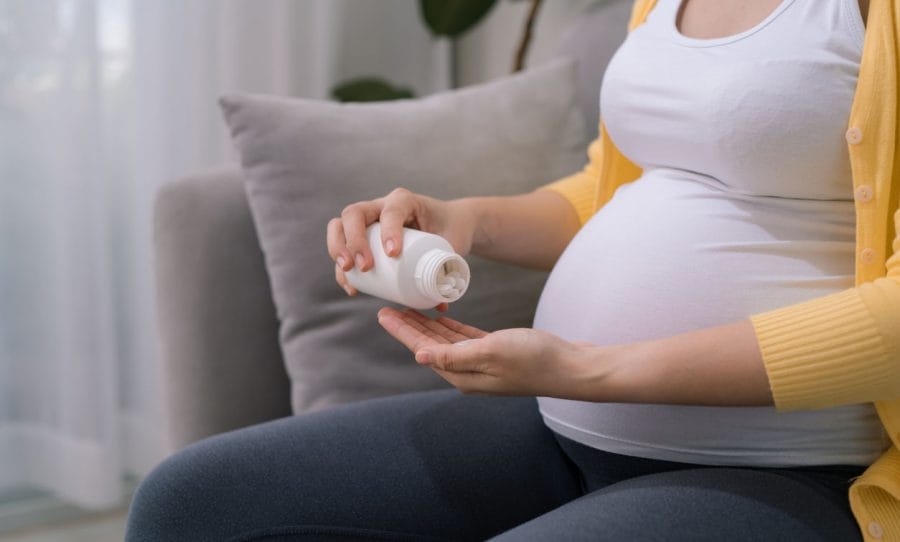 Pregnant woman taking pills.