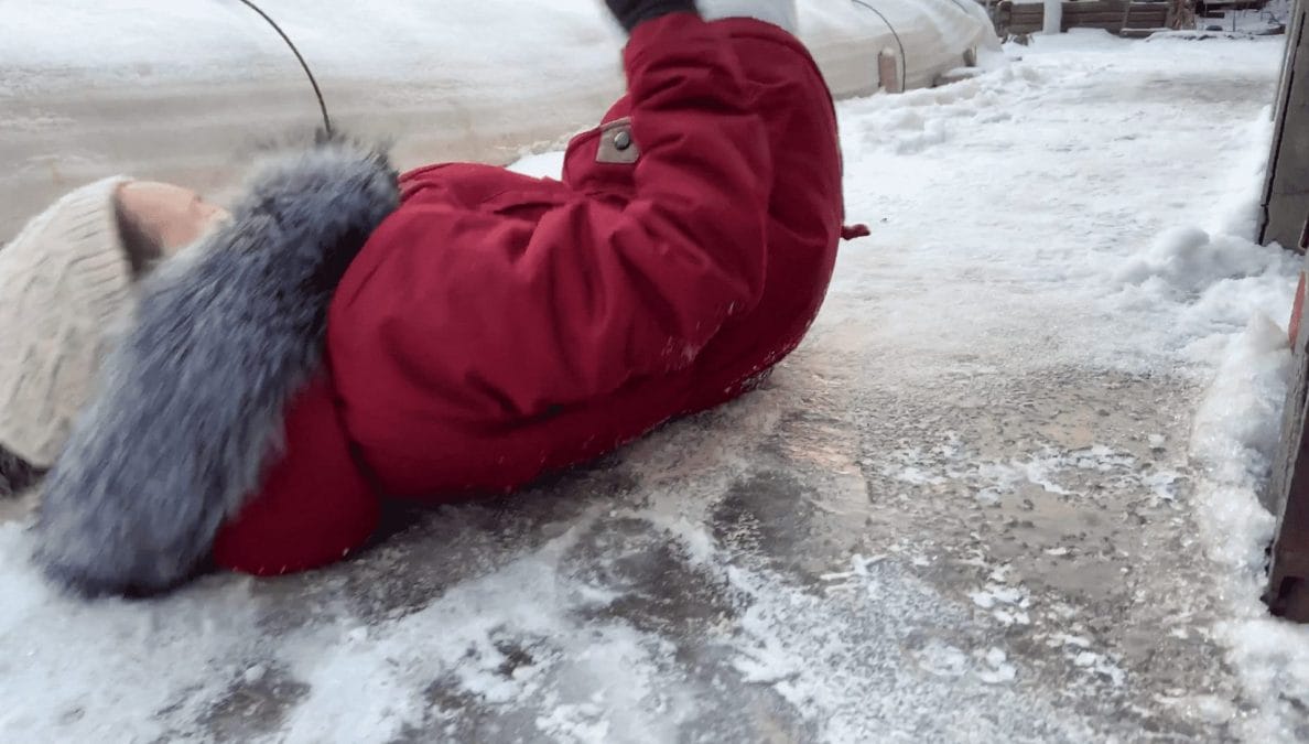 Woman falling down due to ice on the sidewalk